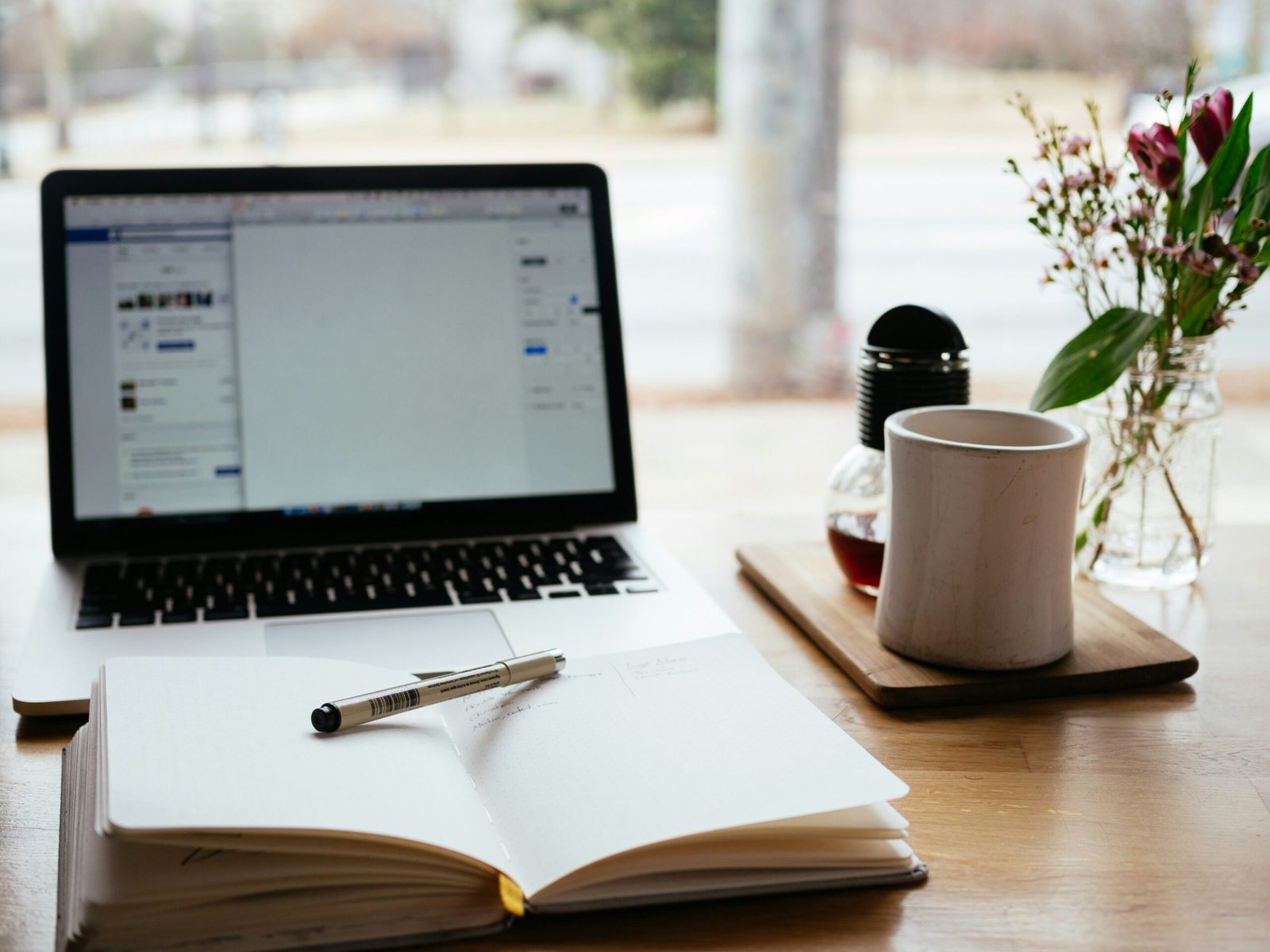 Laptop beside an open book for self-paced eLearning